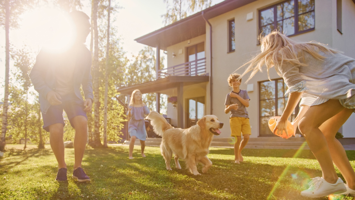 Family playing outdoors with their dog in a clean and comfortable home environment.